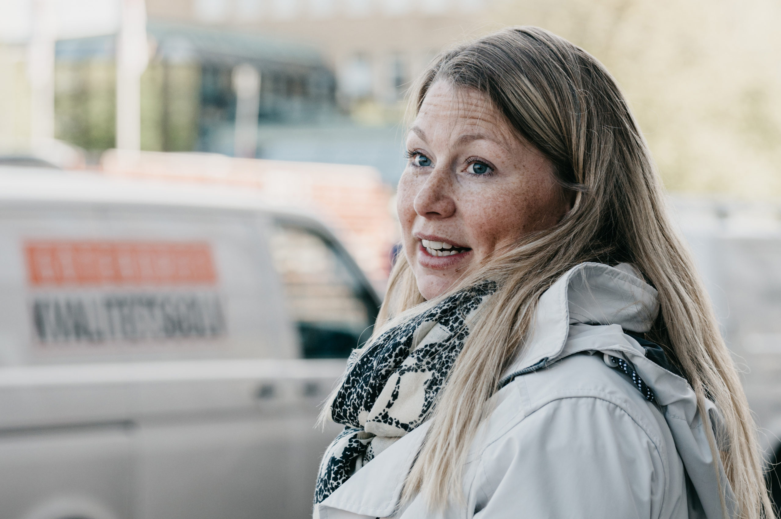 Kvinna i vit jacka och halsduk.