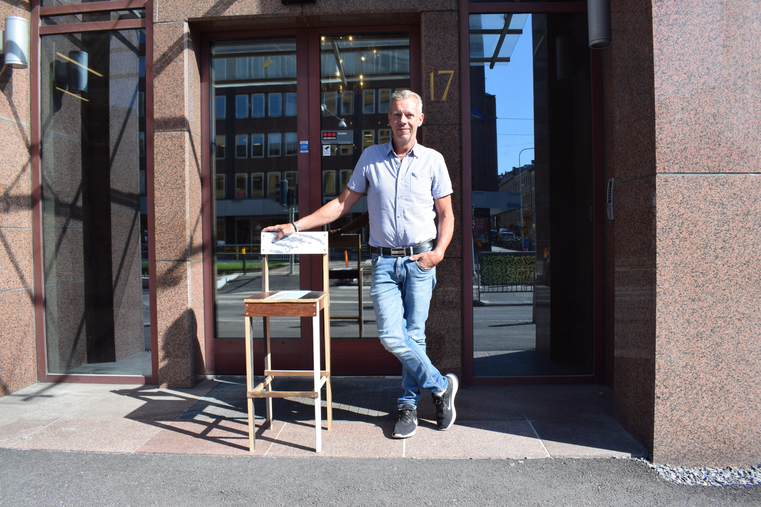 Roland Skogh med en stol som han har byggt själv vid en entré.