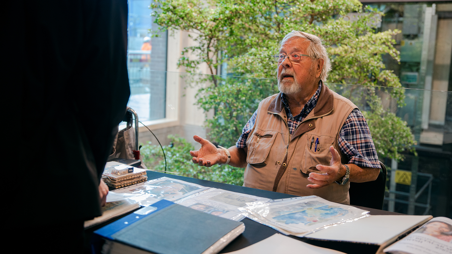 Sven-Eric Svensson vid bord med akvarellmålningar